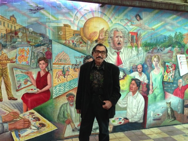 Artist Manuel Varrona standing before his mural in Tijuana